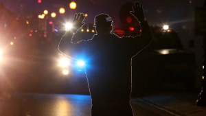 FERGUSON, MO - NOVEMBER 24:  A protestor stands in front of police vehicles with his hands up during a demonstration on November 24, 2014 in Ferguson, Missouri. A St. Louis County grand jury has decided to not indict Ferguson police Officer Darren Wilson in the shooting of Michael Brown that sparked riots in Ferguson, Missouri in August.  (Photo by Justin Sullivan/Getty Images)