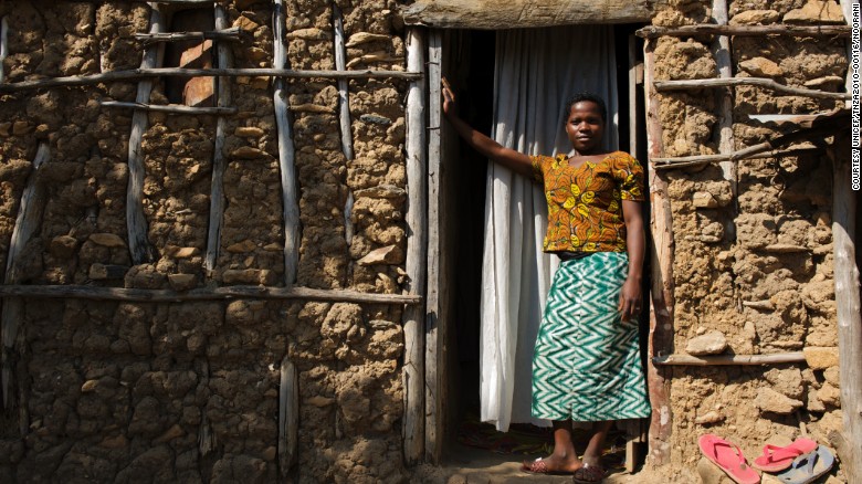 Christina, 14, outside her house where she lives with her husband and  mother-in-law in Tanzania. She was married at 13.  
