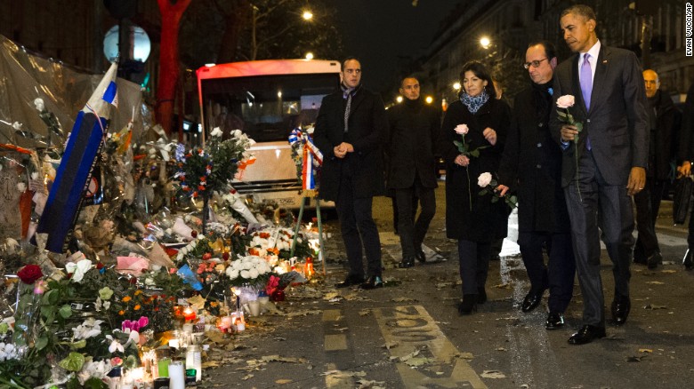 President Barack Obama, French President Francois Hollande, second from right, and Paris Mayor Anne Hidalgo arrive at the Bataclan, site of one of the Paris terrorists attacks, to pay their respects to the victims, on Monday, Nov. 30, 2015, in Paris.