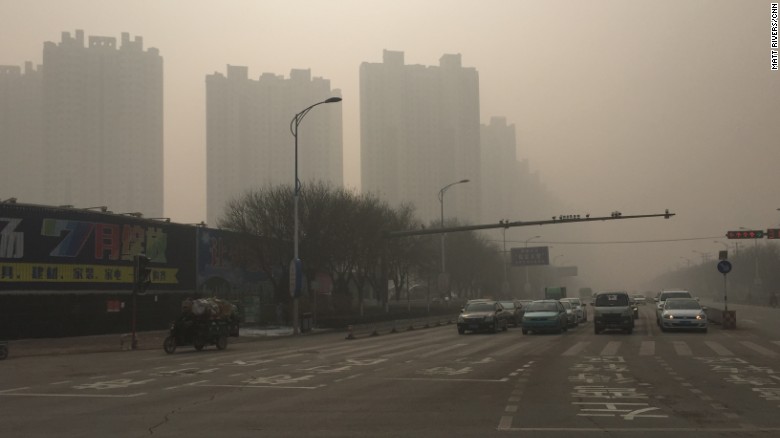Roads and buildings in Baoding, China are seen shrouded in heavy smog on November 30, 2015.