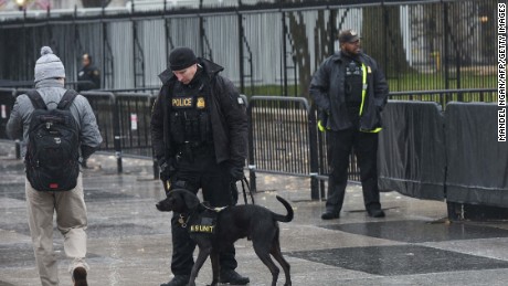 A Secret Service uniformed division dog sniffs at a passer-by in front of the White House on November 30, 2015 in Washington, DC.  