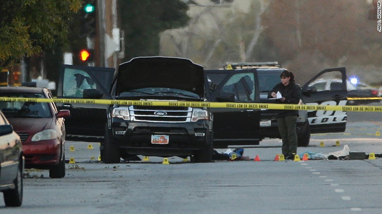 An investigator looks at a Black SUV that was involved in a police shootout with suspects, Thursday, Dec. 3, 2015, in San Bernardino, Calif.  A heavily armed man and woman opened fire Wednesday on a holiday banquet, killing multiple people and seriously wounding others in a precision assault, authorities said. Hours later, they died in a shootout with police.  (AP Photo/Jae C. Hong)