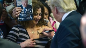 CORRECTIONS PLACE TO PRINCE WILLIAM COUNTY FAIR GROUND FROM PRINCE WILLAM COUNTY FAIRGROUND - Republican presidential candidate Donald Trump autographs a supporter's chest following his speech at a campaign rally at the Prince William County Fair Ground, Wednesday, Dec. 2, 2015, in Manassas, Va. (AP Photo/Cliff Owen)