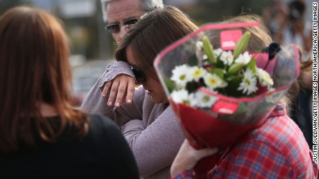 SAN BERNARDINO, CA - DECEMBER 03:  A mourner cries as she brings flowers to a road block outside of the Inland Regional Center on December 3, 2015 in San Bernardino, California. Police continue to investigate a mass shooting at the Center that left at least 14 people dead and another 17 injured.  (Photo by Justin Sullivan/Getty Images)