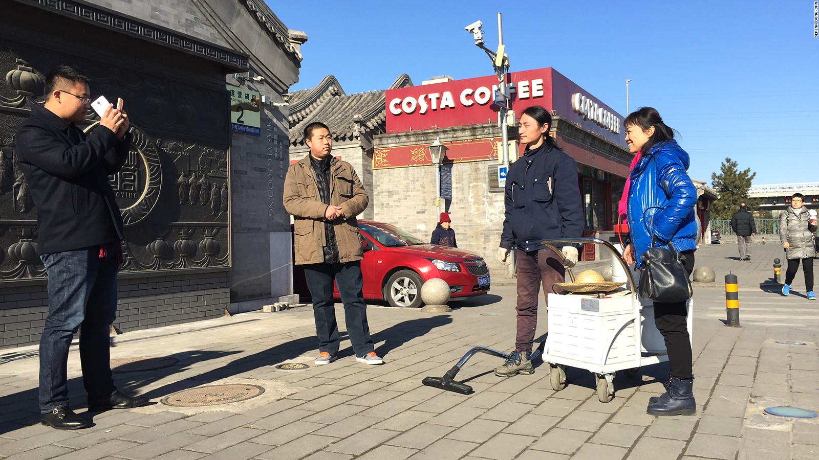 China's Brother Nut taking pictures with his admirers on the pavement.