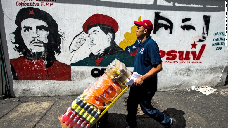 A worker passes propaganda graffiti in Caracas ahead of the vote.