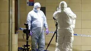 Police officers investigate the tube station late Saturday, December 5.