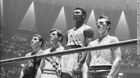 The winners of the 1960 Olympic medals for light heavyweight boxing on the winners' podium at Rome: Cassius Clay (now Muhammad Ali) (C), gold; Zbigniew Pietrzykowski of Poland (R), silver; and Giulio Saraudi (Italy) and Anthony Madigan (Australia), joint bronze.   (Photo by Central Press/Getty Images)
