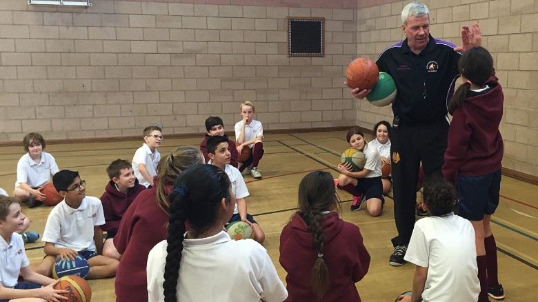 Basketball coach Bob Martin talks to children about the sport.