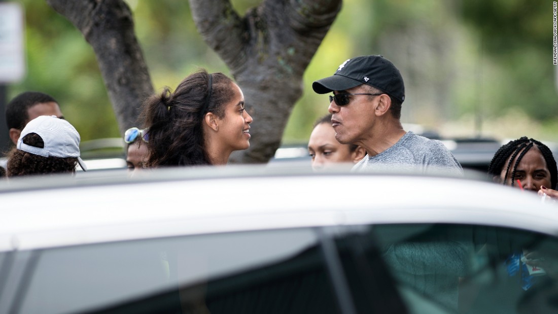 Obama talks with his daughter Malia while stopping for shave ice at Island Snow.