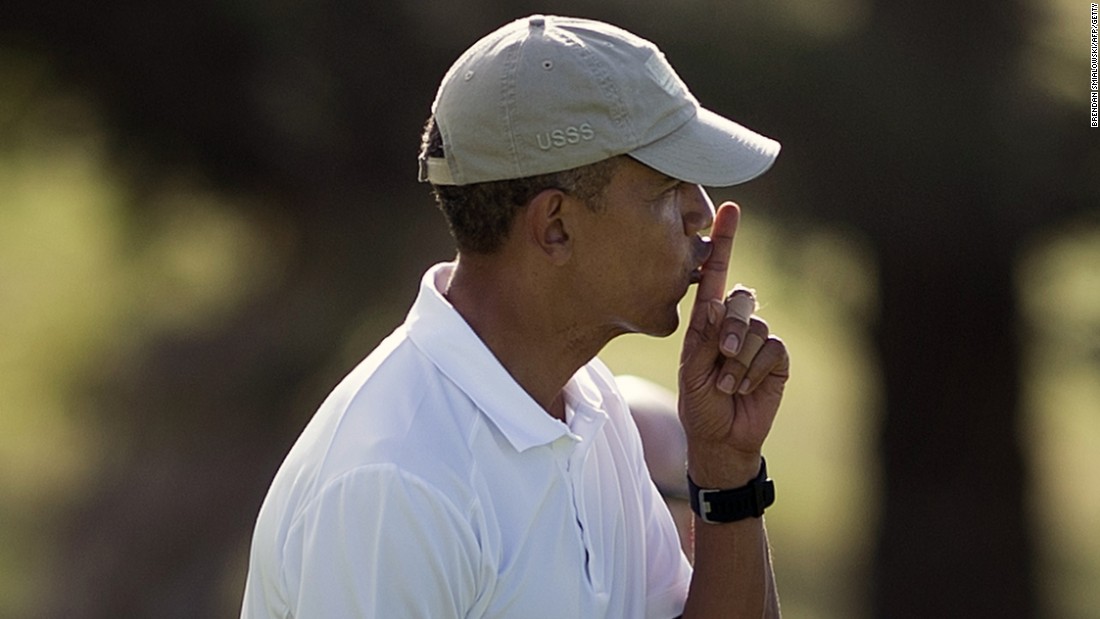 Obama gestures for quiet on the 18th green at the Mid Pacific Country Club golf course on Monday, December 28, in Kailua.