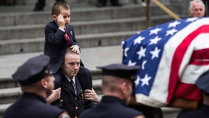 NEW YORK, NY - DECEMBER 30:  Ryan Lemm, age four, the son of New York Police Department (NYPD) Detective and Air National Guard Sergeant Joseph Lemm, salutes while his father's casket is brought out of St. Patrick's Cathedral after his father's funeral on December 30, 2015 in New York City. Lemm was killed on his third tour of duty in Afghanistan on December 21.  (Photo by Andrew Burton/Getty Images)