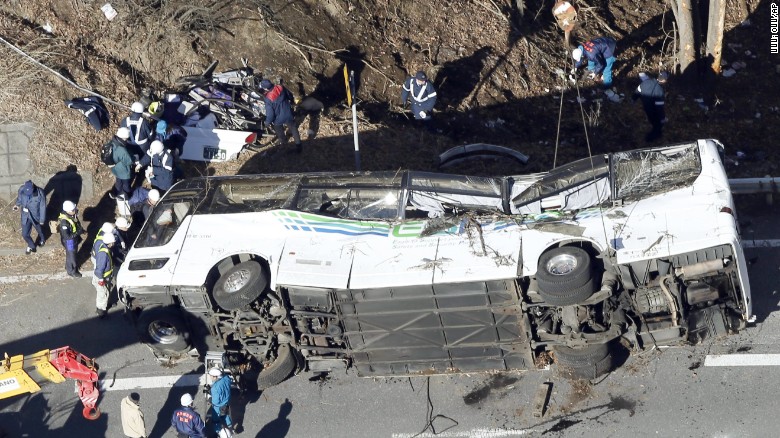 Investigators work near the damaged wreck after it was transferred by crane onto a road in Karuizawa, Nagano prefecture, central Japan Friday, Jan. 15, 2016. 