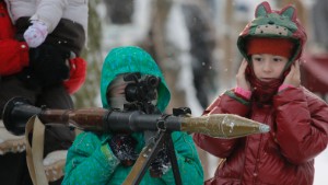 A boy aims an RPG at a weapons exhibition during a military show in St.Petersburg, Russia, Sunday, Jan. 17, 2016. (AP Photo/Dmitry Lovetsky)