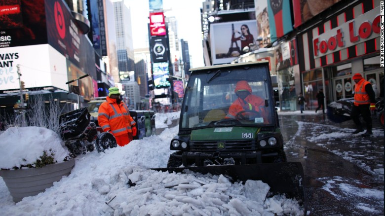 Times Square employees clean a snow covered street in Times Square on January 24, 2016 in New York. 
A massive blizzard that claimed at least 16 lives in the eastern United States finally appeared to be winding down Sunday, giving snowbound residents the chance to begin digging out. / AFP / KENA BETANCUR        (Photo credit should read KENA BETANCUR/AFP/Getty Images)