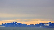 The midnight sun casts a golden glow, hovering just above the horizon as it struggles to climb the earth's curvature at this latitude.