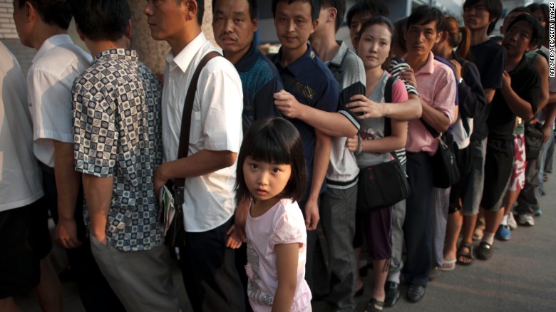This picture taken in August 2011 shows a girl standing beside her father as hundreds of Chinese parents queue up to see a doctor outside a children&#39;s hospital in Beijing. 