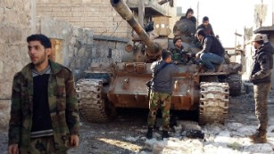 Syrian government forces chat by a tank near the Shiite villages of Nubul and Zahraa.