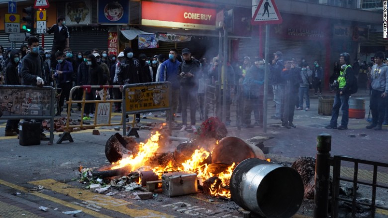 Fires lit by protesters burn at an intersection in one of Hong Kong&#39;s busiest shopping districts. 