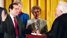 Retiring Chief Justice Warren Burger, right, administers an oath to Associate Justice Antonin Scalia, as Scalia's wife, Maureen, holds the Bible on September 26, 1986. Scalia was the 103rd person to sit on the court.