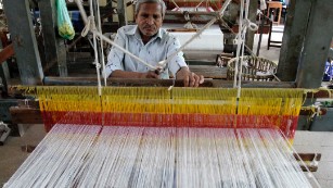 An Indian man weaves cloth at a handloom factory in Ahmadabad, India.