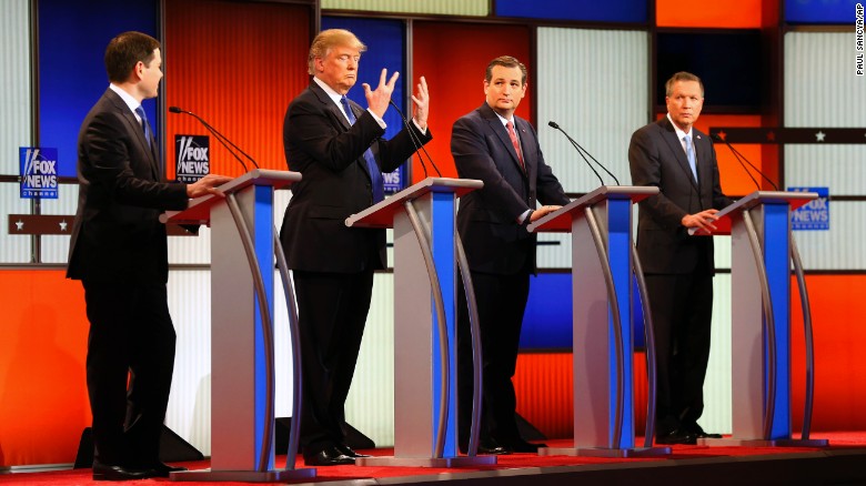 Republican presidential candidate, businessman Donald Trump, second from left, gestures as Sen. Marco Rubio, R-Fla., Sen. Ted Cruz, R-Texas, and Ohio Gov. John Kasich watch him a Republican presidential primary debate at Fox Theatre, Thursday, March 3, 2016, in Detroit