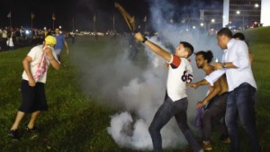 Demonstrators return tear gas to riot police during a protest against corruption in front of the Congress building in Brasilia on March 16. 