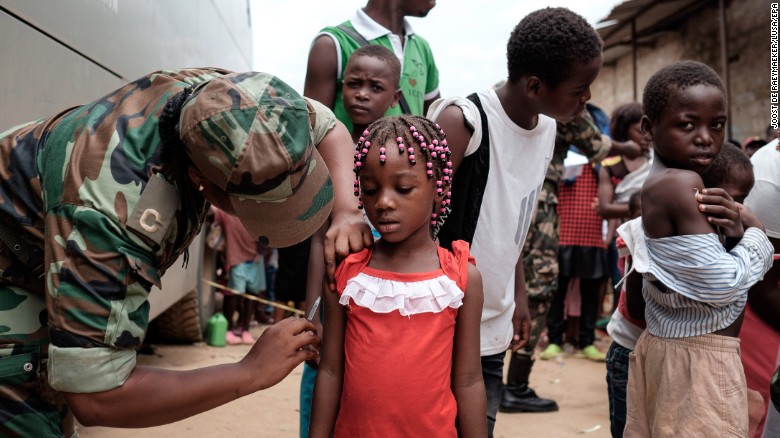 Angolan military administers a yellow fever vaccine to a child at 'Quilometro 30' market, Luanda, Angola.
