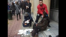 A private security guard helps a wounded woman outside the Maalbeek metro station in Brussels.