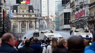 Police use water cannons to disperse anti-immigration protesters at a memorial site for victims of the Brussels attacks. 