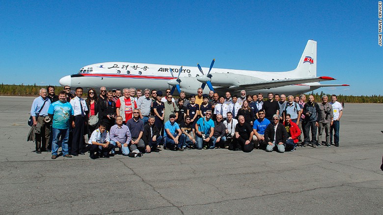 Members of Juche's 2014 tour stand in front of an Ilyushin IL-18 at North Korea's Samjiyon Airport in Ryanggang province.