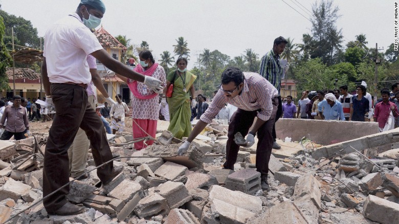 People search through the debris of a a collapsed building after a massive fire broke out during a fireworks display at the Puttingal temple complex in southern India on Sunday, April 10. Scores of people were killed and hundreds more injured in the fire, caused when an unauthorized fireworks show ignited a separate batch of fireworks that were being stored at the temple complex.