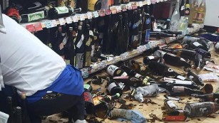 A shop clerk clears broken wine bottles after the quake in Japan. 