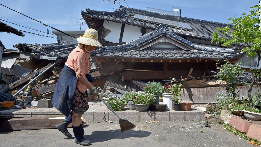 A woman cleans up in front of her collapsed house in the town of Mashiki, Kumamoto prefecture, on Friday, April 15. A magnitude-6.2 earthquake hit Japan&#39;s southwestern island of Kyushu on Thursday, collapsing homes and sparking fires, officials said.