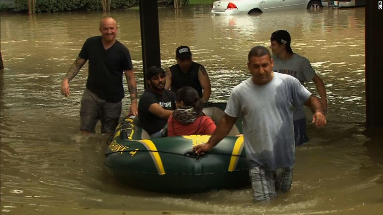 Neighbors pull Ahmed Sharma and his wife, Emily, to safety after floodwater deluged their apartment complex in Klein, Texas.