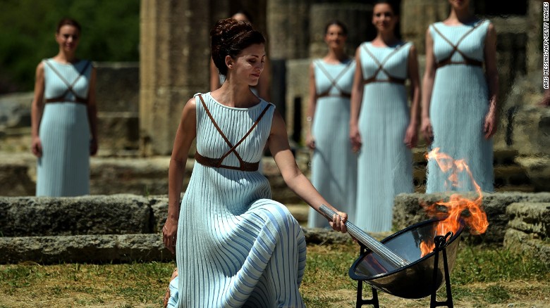 The Olympic flame is back: Greek actress Katerina Lechou performs the role of the high priestess as she lights the Olympic flame at the Temple of Hera at the site of ancient Olympia.