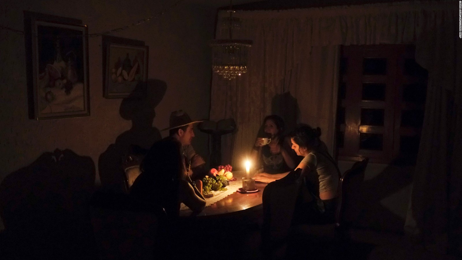 A family sit at a candle lit table in the state of Barinas, Venezuela on April 25.