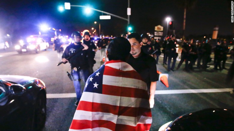 Protestors are pushed off the street by law enforcement after a rally for Republican presidential candidate Donald Trump, Thursday, April 28, 2016 in Costa Mesa, Calif. (AP Photo/Chris Carlson)