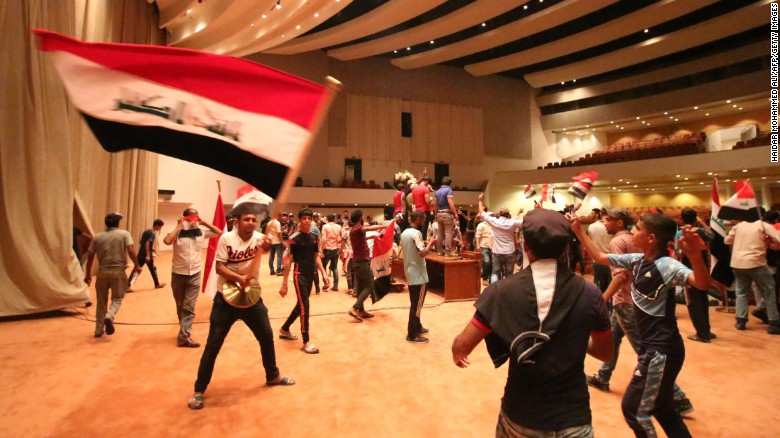 Iraqi protesters wave national flags inside Parliament after breaking into Baghdad&#39;s heavily fortified &quot;Green Zone&quot; on April 30, 2016. 