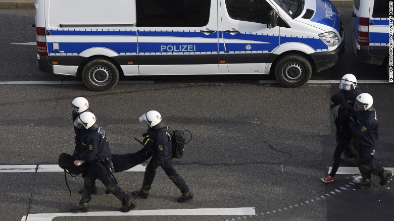 Police forces take protesters into custody during a demonstration against a party congress of the German right wing party AfD. 