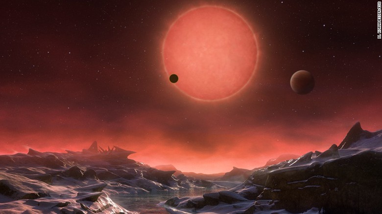 This artist&#39;s impression shows an imagined view from the surface one of the three planets orbiting an ultracool dwarf star just 40 light-years from Earth that were discovered using the TRAPPIST telescope at ESO&#39;s La Silla Observatory. These worlds have sizes and temperatures similar to those of Venus and Earth and are the best targets found so far for the search for life outside the Solar System. They are the first planets ever discovered around such a tiny and dim star. In this view one of the inner planets is seen in transit across the disc of its tiny and dim parent star.