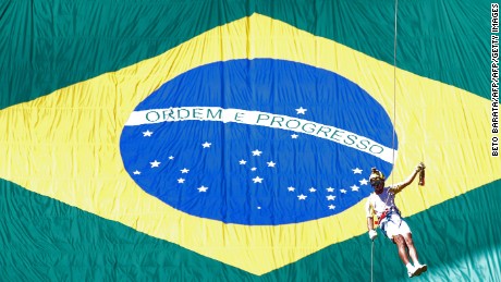 Brazilian fireman Haudson Alves descends from a helicopter carrying the Olympic flame on a lantern at the Brasilia National Stadium in Brasilia on May 3, 2016.Embattled President Dilma Rousseff greeted the Olympic flame in Brazil on Tuesday, promising not to allow a raging political crisis, which could see her suspended within days, to spoil the Rio Games. The torch will now be carried in a relay by 12,000 people through 329 cities, ending in Rio&#39;s Maracana stadium on August 5 for the opening ceremony. / AFP / BETO BARATA (Photo credit should read BETO BARATA/AFP/Getty Images)