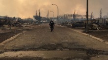 A member of the Royal Canadian Mounted Police surveys wildfire damage in Fort McMurray. The RCMP tweeted the photo on Thursday, May 5.