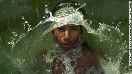 DHAKA, BANGLADESH - APRIL 29 : A Bangladeshi boy swims at the Hatirjheel Lake to cool himself during a hot day in Dhaka, Bangladesh, on April 29, 2016. (Photo by zakir hossain chowdhury/Anadolu Agency/Getty Images)
