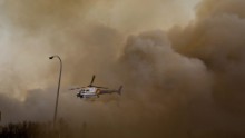 A police helicopter lifts off through dust and smoke on May 6. 