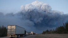 Drivers wait for clearance to take firefighting supplies into town on Thursday, May 5, outside Fort McMurray, Alberta. 