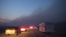 RCMP officers man a checkpoint on the highway to Fort McMurray as wildfires burn out of control on May 6.  