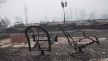 Skeletons of patio furniture and smoldering home foundations are all that remain in parts of a residential neighborhood on May 7. 