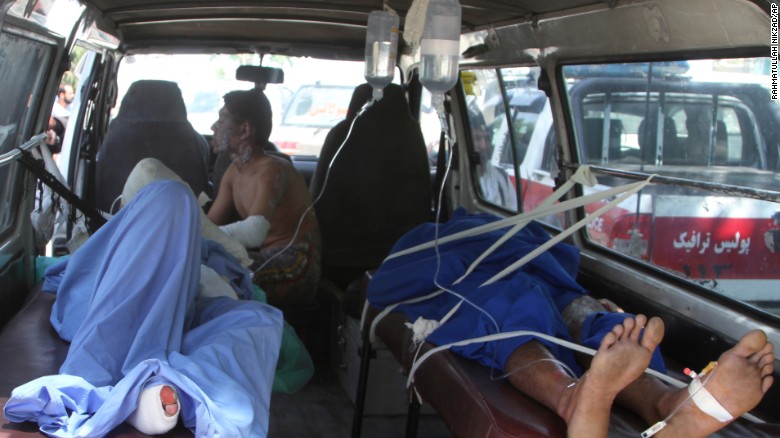 Injured Afghan men lie in an ambulance after a deadly road accident in Afghanistan Sunday.