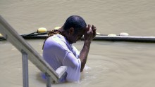 A pilgrim immerses himself in the waters of the Jordan River. UNESCO recognizes the official site of Jesus' baptism as the east bank of the river in Jordan, called Al-Maghtas ("baptism").